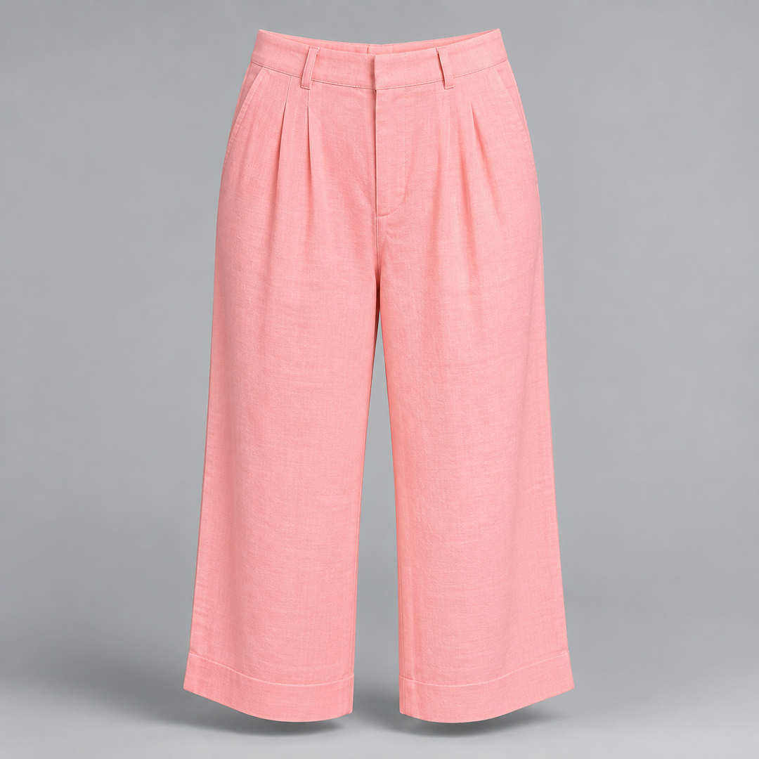 A pair of high-waisted, wide-leg cropped pants in a soft pink color, featuring pleated detailing down the front and a button closure, shown against a solid gray background.