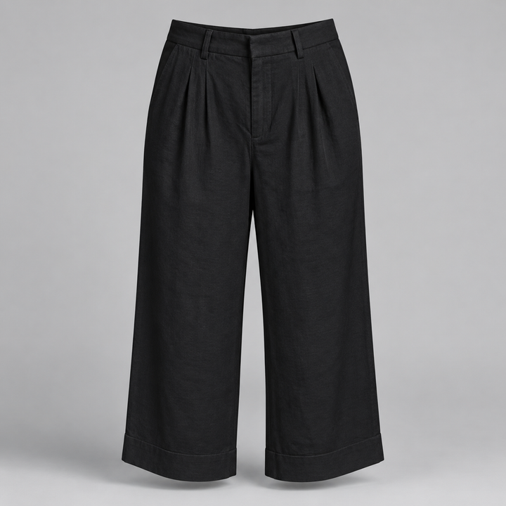 Black wide-leg cropped pants with pleated detailing at the front, shown on a neutral gray background.